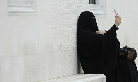 Muslim woman wearing a niqab taking a selfie